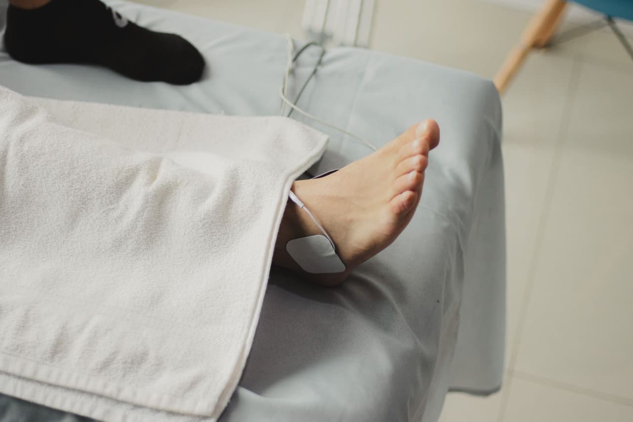 Electrical stimulation pads attached to a patient with a small control unit nearby